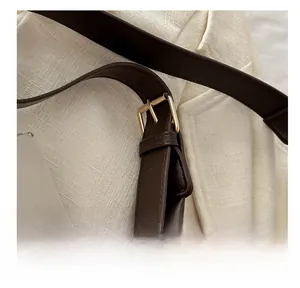 Close-up of adjustable golden buckle and premium dark brown leather strap detail