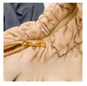 Detail showing smooth gold metal zipper on quilted cloud shoulder bag fabric