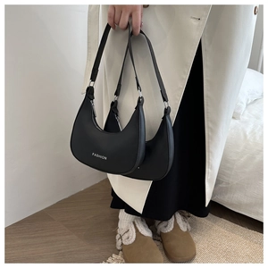 Detail view of black hobo bag showing the white FASHION print and smooth matte texture