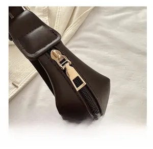 Close-up of a smooth gold zipper on a dark brown premium PU leather handbag