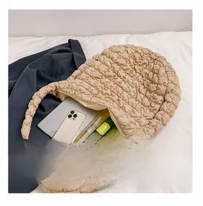 Detail view of the spacious inner compartment of the beige quilted cloud bag