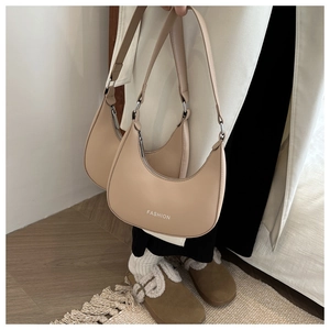 Detail view of beige leather hobo bag with Fashion text and adjustable shoulder strap