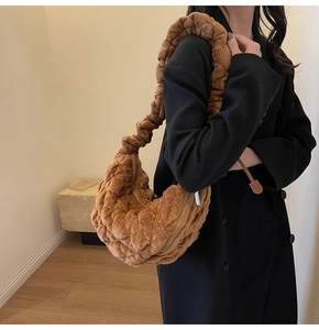 Detail view of the brown velvet cloud bag with pleated shoulder strap and quilted texture