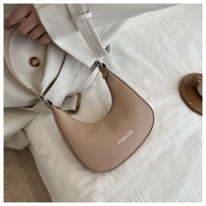 Detail view of the beige half-moon PU leather bag with white FASHION print on fabric