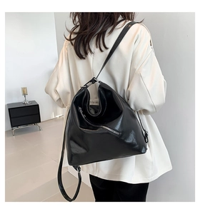 Détail du sac à bandoulière tendance en PU noir avec fermeture éclair diagonale sur mannequin