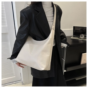 Close-up of minimalist cream white large hobo shoulder bag with matte leather texture