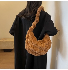 Detail of caramel velvet quilted shoulder bag with ruched strap and soft half-moon shape