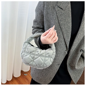 Detail of grey quilted plush handbag with a soft cloud texture and elegant diamond stitching