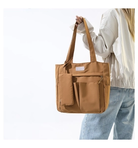 Detail of caramel nylon tote bag with fashion label and detachable small zipper pouch