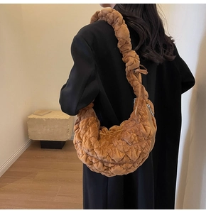 Detail of caramel brown velvet quilted shoulder bag with soft pleated cloud design