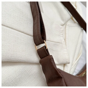 Detailed close-up of brown PU leather tote bag with gold D-ring hardware and stitching