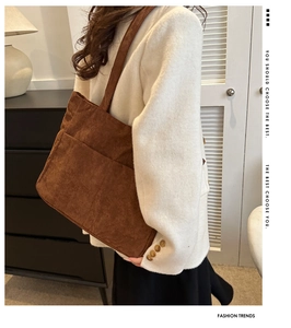 Detail of dark brown corduroy tote bag showing ribbed texture and exterior pocket