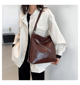 Sac bandoulière en cuir ciré marron foncé avec finition brillante et zip argenté