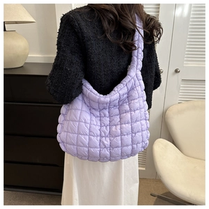 Détail du sac cabas matelassé lilas avec texture bouffante porté à l'épaule