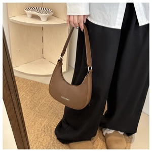 Detailed close-up of brown PU leather hobo bag with Fashion logo and silver zipper