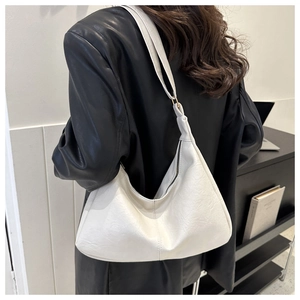 Modern white PU leather hobo bag worn by model showing style and shoulder strap fit
