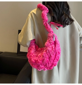 Detail showing bright pink plush handbag with bubble texture and pleated shoulder strap