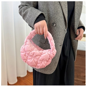 Detailed close-up of a pink quilted crescent handbag made of soft plush velvet material