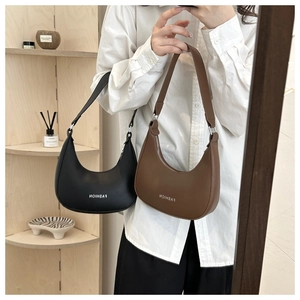 Detail of minimalist matte PU leather crescent bag in black and brown with zipper
