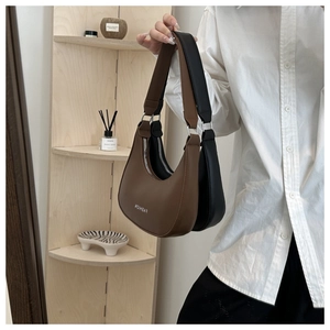 Detail of half-moon underarm bags in brown and black leather with Fashion text