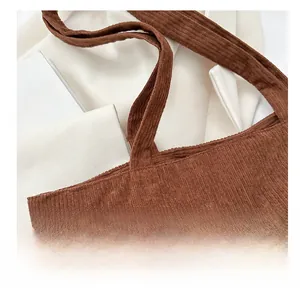 Detailed close-up of dark brown corduroy tote bag strap with vintage texture and fine stitching