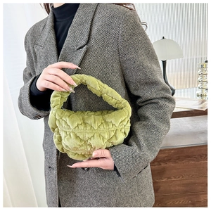 Detail of fruit green quilted velvet handbag with plush texture and half-moon design