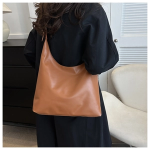 Close-up of caramel PU leather hobo bag showing smooth texture and half-moon design