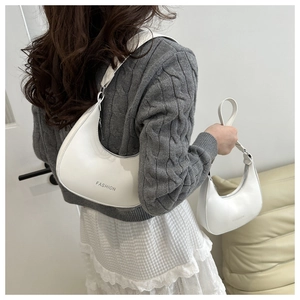 Detail showing two sizes of white PU hobo bags worn with a casual gray sweater