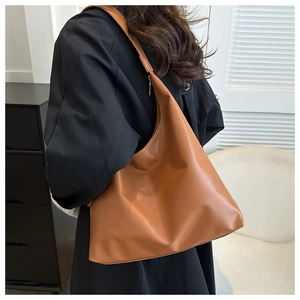 Detail of caramel brown PU leather hobo bag showing soft texture and large capacity on model