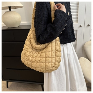 Sac fourre-tout matelassé beige en coton soufflé présenté dans un cadre de vie intérieur