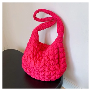 Detailed macro view of bright pink quilted popcorn textured fabric on large shoulder bag