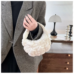Close-up of white plush handbag with quilted star patterns and a soft fur texture