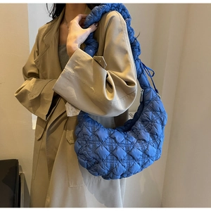 Detail of navy blue quilted puffer hobo bag with stylish scrunchie shoulder strap