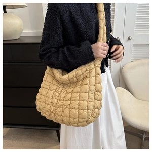 Gros plan détaillé d'un sac cabas beige matelassé montrant sa texture douce et nuageuse