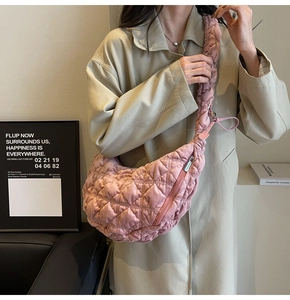 Detail of pink quilted crescent bag with ruffled shoulder strap and chic pleated design