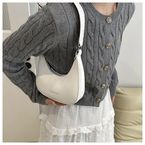 Detail of white PU leather hobo bag featuring printed fashion text and metal strap buckle