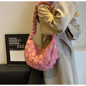 Detail of pink quilted bubble fabric shoulder bag with textured strap and puffy design