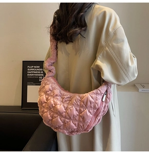 Detail of pink quilted hobo bag featuring plush fabric texture and crescent shape