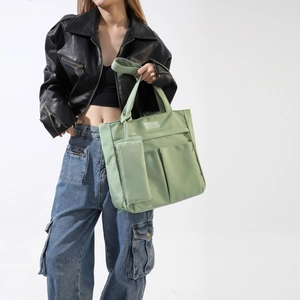 Light green nylon tote bag with fashion tag and matching pouch in street style view