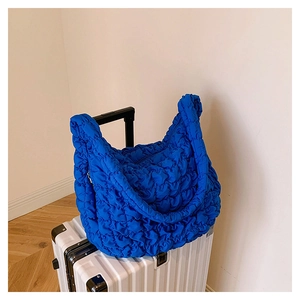 Detail of Klein blue quilted cloud bag showing puff texture and waterproof nylon fabric