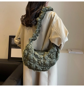 Detail of dark green quilted velvet shoulder bag with a scrunchie pleated strap