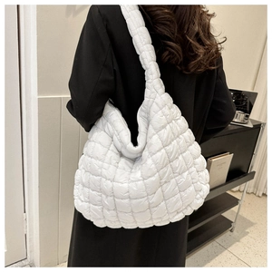 Vue détaillée du sac bandoulière matelassé blanc montrant la texture douce et le volume