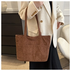 Close-up of brown corduroy tote bag with large front pockets and dual shoulder straps