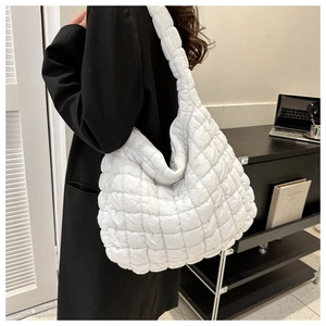 Vue détaillée du sac cabas matelassé blanc porté par un mannequin dans un bureau moderne
