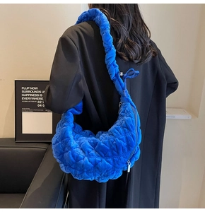 Detail of blue quilted hobo bag with unique scrunchie strap and velvet texture