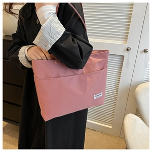 Dettaglio della borsa tote rosa che mostra la trama resistente e l'etichetta fashion
