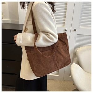 Detail showing high-end brown corduroy tote bag texture and front compartment pocket