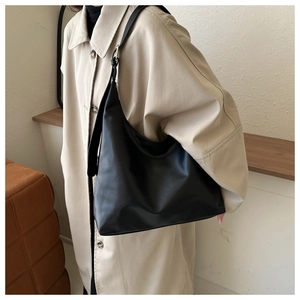 Minimalist black matte PU leather hobo shoulder bag for women styled with a beige coat