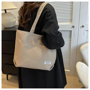 Dettaglio borsa tote in tela beige di alta qualità con etichetta tessuta alla moda