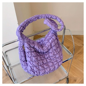 Close-up of the purple quilted cloud bag showing the soft nylon fabric and golden zipper